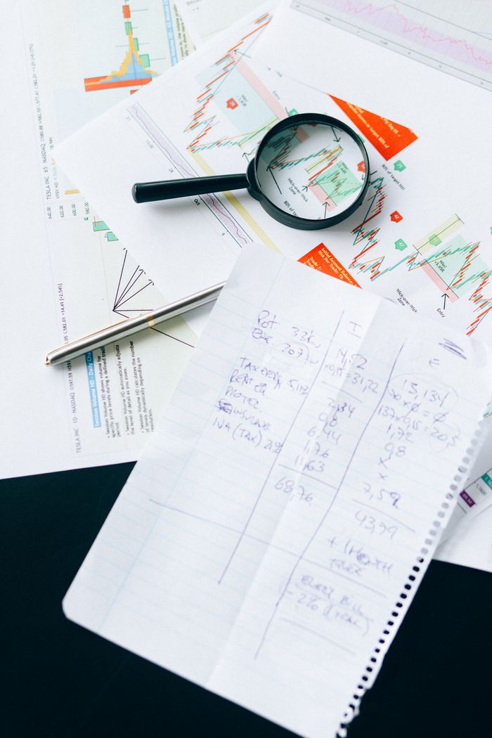 Mastering the First Impression: Your intriguing post title goes here Financial documents and charts with a magnifying glass, symbolizing analysis and data review.