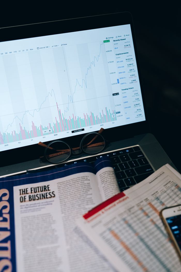 Crafting Captivating Headlines: Your awesome post title goes here Close-up of laptop screen with business analytics, book, and eyeglasses.